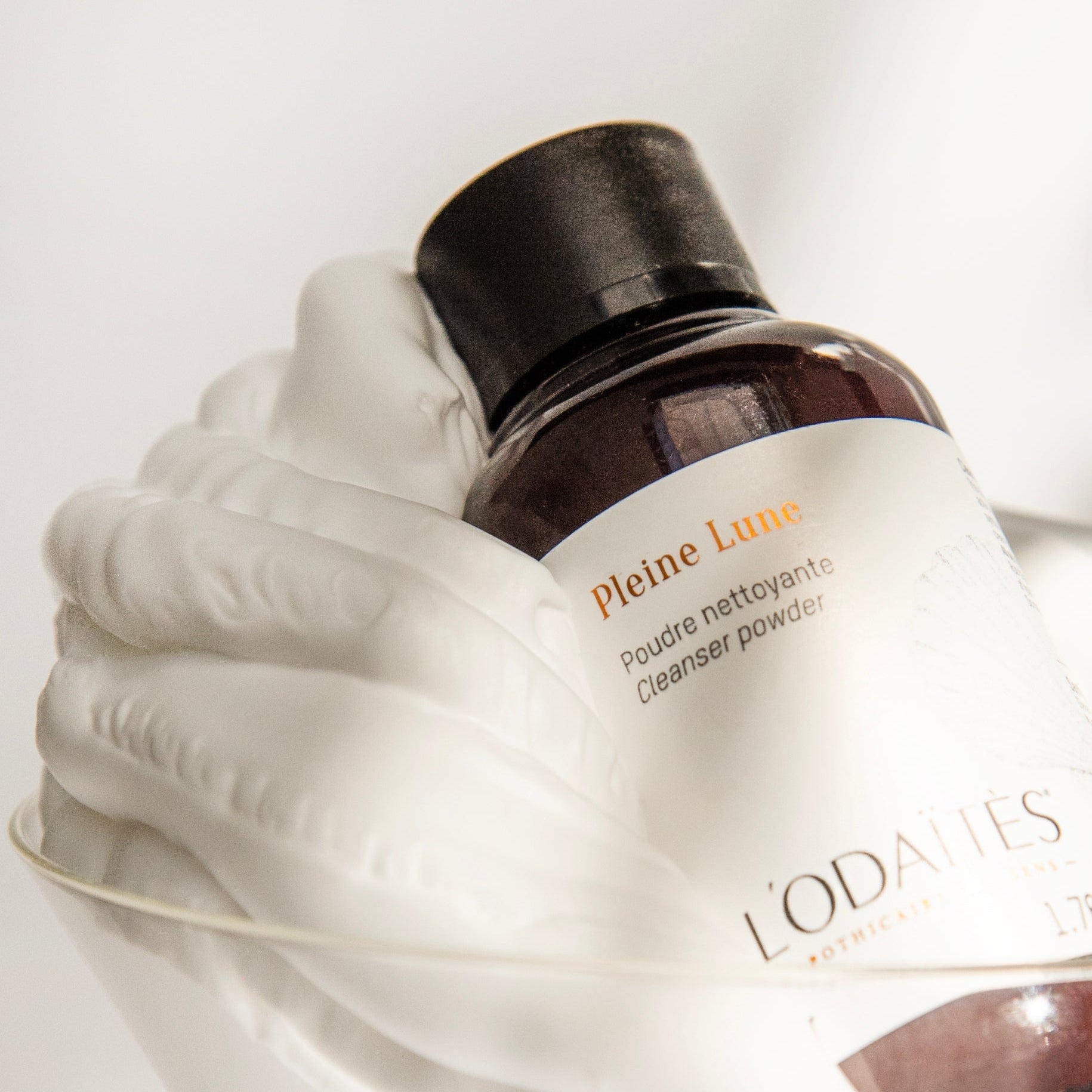 L'Odaïtès cleansing powder in a glass full of foam